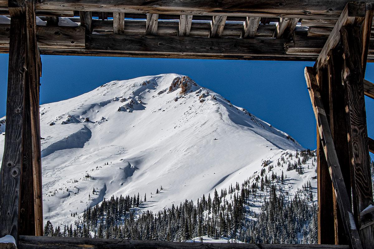 Four Corners Photographic Society photo of a snowy mountain top, trees at the bottom of the hillside looking through a pergola